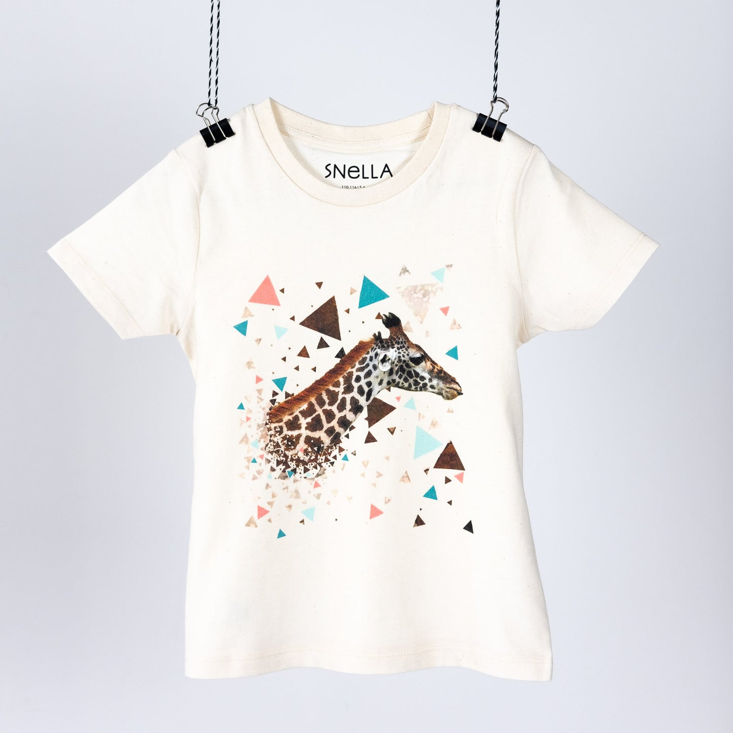 Children's t-shirt hanging like a piece of art. Natur with a digital print of a giraffe baby and colourful triangles. Screen print in neck area. Front view. 
